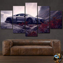 Load image into Gallery viewer, Audi R8 Canvas wall art set featuring a sleek silver Audi R8 on rocky terrain with autumn foliage, displayed above a brown leather sofa