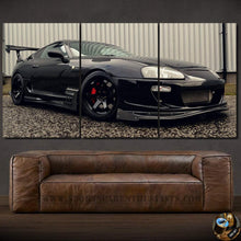 Load image into Gallery viewer, Black Toyota Supra MK4 sports car canvas wall art above brown leather sofa
