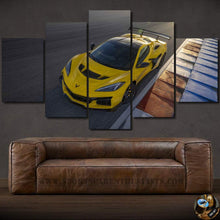 Load image into Gallery viewer, Chevrolet Corvette Canvas wall art featuring a yellow sports car race track scene in five-panel framed design above a brown leather sofa.