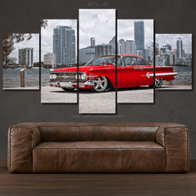 Load image into Gallery viewer, Chevy Impala 1960 red classic car multi-panel canvas wall art with city skyline background above brown leather sofa