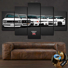 Load image into Gallery viewer, Nissan GTR R35 wallpaper canvas print featuring a lineup of Nissan GT-R models displayed above a brown leather sofa with a free gear shifter keychain gift.