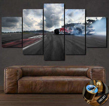 Load image into Gallery viewer, Mazda RX7 Rotary drifting on racetrack canvas wall art with smoky tires and cloudy sky split into five panels above brown leather sofa