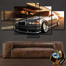 Load image into Gallery viewer, BMW E36 canvas wall art print featuring a silver sports car in a five-piece framed set above a brown leather sofa with free gear shifter keychain gift