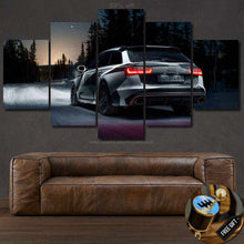 Load image into Gallery viewer, Audi RS6 Canvas multi-piece wall art showing rear view of silver Audi RS6 on snowy road at dusk above brown leather sofa
