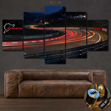 Load image into Gallery viewer, Nurburgring Canvas wall art showing illuminated race track curves at night, five-panel framed print above brown leather sofa with free gear shifter keychain gift.