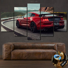 Load image into Gallery viewer, Five-piece framed Ford Mustang wallpaper canvas wall art showing a red sports car on a mountain road above a brown leather sofa