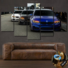 Load image into Gallery viewer, BMW M3 F80 M4 F82 multi-panel canvas wall art featuring front view of three sports cars with illuminated headlights above brown leather sofa