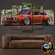 Load image into Gallery viewer, Five-piece framed BMW E30 canvas wall art depicting a classic red sports car above a brown leather sofa, perfect for car enthusiasts.