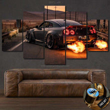 Load image into Gallery viewer, Multi-panel Nissan GTR R35 wallpaper print with fiery exhaust flames above a brown leather sofa