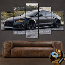 Load image into Gallery viewer, Audi Canvas wall art featuring a sleek black Audi car in five-panel framed canvas print above a brown leather sofa.