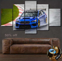 Load image into Gallery viewer, Nurburgring Nordschleife wallpaper canvas set featuring a blue Subaru race car drifting on a racetrack above a brown leather sofa