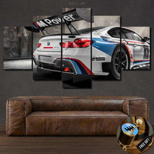 Load image into Gallery viewer, Multi-panel canvas wall art featuring a BMW M6 GT3 race car with M Power branding above a brown leather sofa