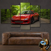 Load image into Gallery viewer, Mazda RX7 Canvas wall art showing red sports car in forest, five-piece framed canvas print above brown leather sofa, free gear shifter keychain gift included.