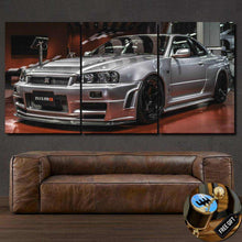 Load image into Gallery viewer, Triptych canvas wall art featuring a silver Nissan GT-R R34 sports car displayed above a brown leather sofa, with a free gear shifter keychain gift inset.