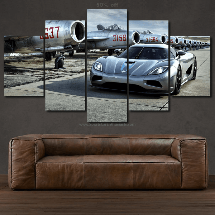 Five-piece canvas wall art featuring a silver Koenigsegg Agera parked in front of vintage airplanes, displayed above a brown leather sofa.