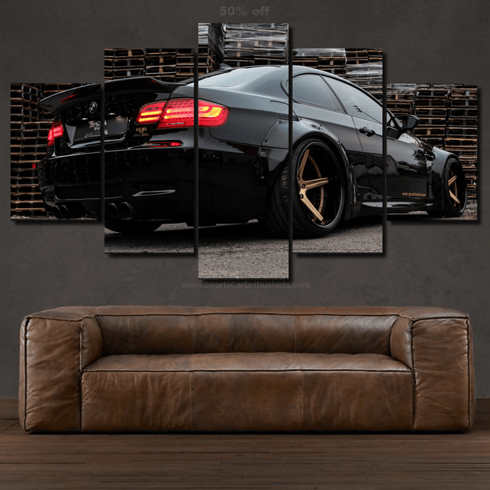 BWM E92 M3 black sports car canvas wall art in multiple panels above a brown leather sofa