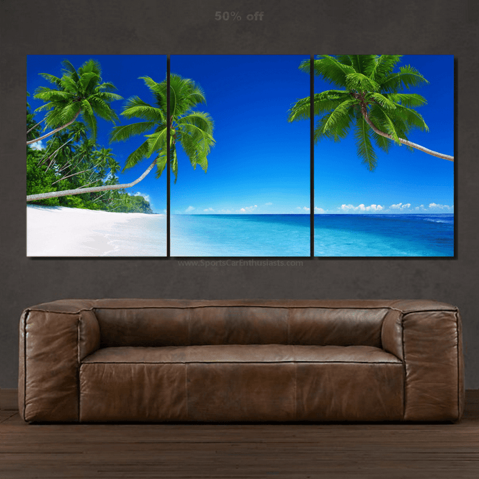 Canvas 3pcs wall art set featuring tropical beach with palm trees and blue sky above brown leather sofa