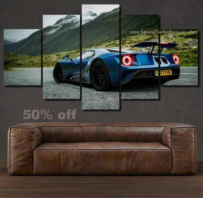 5-piece Ford GT canvas wall art featuring a blue sports car in a mountainous landscape above a leather sofa